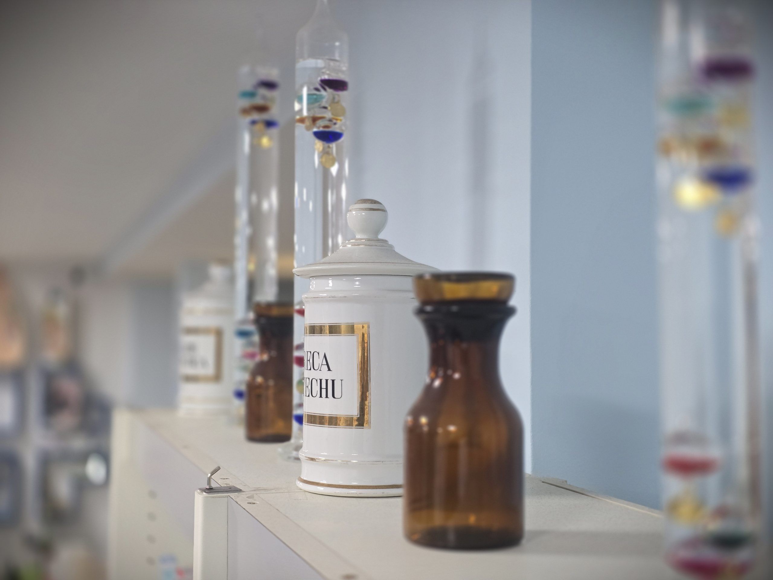 fotografía de tarros de farmacia y termómetros de galileo